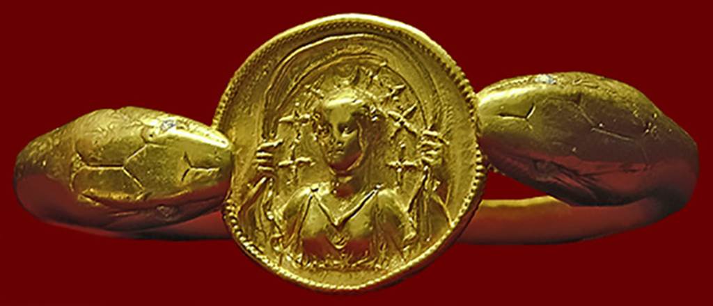 VI.17.42 Pompeii. Golden bracelet found on the arm of a woman.
According to Barbara McManus, this remarkable bracelet, 610 grams (21.5 oz) of solid gold, is fashioned in the form of two snakes flanking a round disk with a carved relief of Selene with crescent moon and stars above her head. 
It was found on the arm of a woman carrying a casket containing 40 aurei and 180 denarii. 
She was killed along with another adult and a child when a balcony collapsed in the house.
Photo courtesy of Barbara McManus. See The VRoma Project 
Now in Naples Archaeological Museum.  Inventory number 14268.