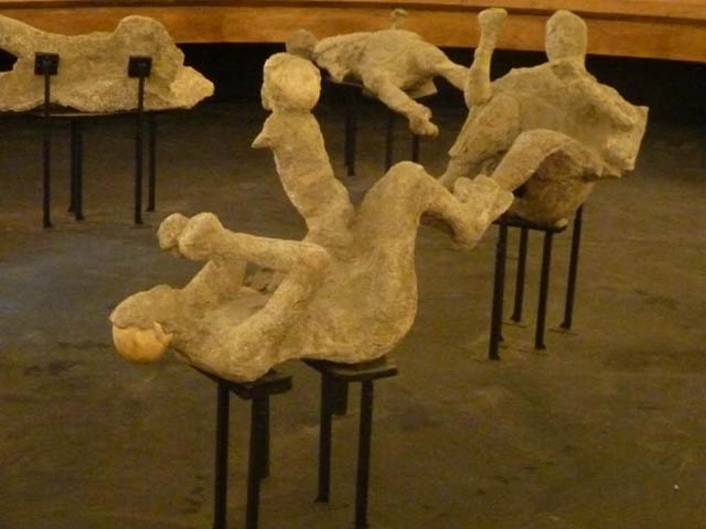 VI.17.42 Pompeii. September 2015. Plaster casts of a group of three fugitives found between 3rdand 6th June 1974, in a corridor of the lower level. The group consisted of two individuals, one was identified as a woman because of the golden bracelet that she wore on her right arm, and a child. Nearby was a man. A short distance away, a very young victim of about four years of age was found. Exhibit from the Summer 2015 exhibition in the amphitheatre.