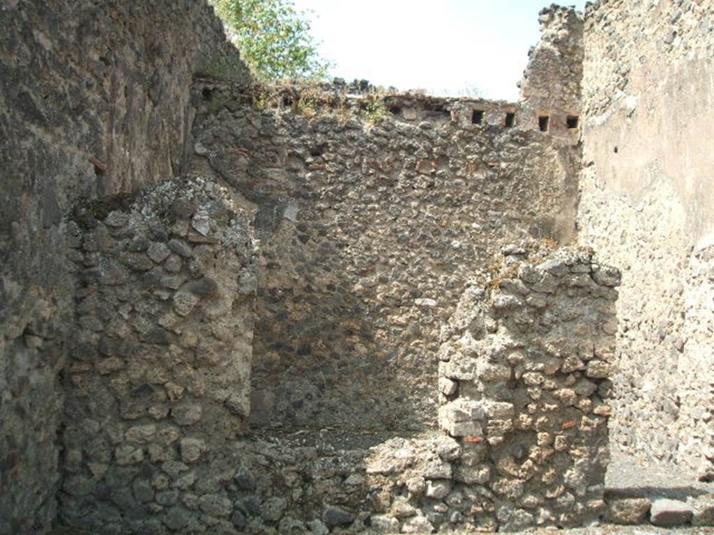 VII.1.20 Pompeii. May 2005. West wall of shop, with window and doorway to rear room.
According to Fiorelli, a painting of Bacchus accompanied by his panther, was found in this room in the middle of two obscene paintings.
See Pappalardo, U., 2001. La Descrizione di Pompei per Giuseppe Fiorelli (1875). Napoli: Massa Editore. (p.75)
“E poco innanzi con lo stesso sistema di escavazione orizzontale rinvenivasi a dodici palmi dal pavimento l’intero scheletro di un Ostiario con chiave di ferro nella sinistra mano, in cui aveva l’anello di bronzo ossidato, al quale quella chiave stava infilzata, giacente sul sinistro fianco in una stratificazione molto compatta prossima ad un angolo della bottega no.65.”
See Real Museo Borbonico, vol. 15, 1856, (p.12 of “Relazione degli Scavi di Pompei, da Marzo 1862 a dicembre 1855”).
(trans: And found a little further on with the same system of horizontal excavation, twelve palms (3.16 metres) from the floor, the entire skeleton of a man (Ostiario) with iron key in his left hand, in which he had an oxidized bronze ring, to which that key was attached, lying on the left side in a very compact stratification close to a corner of the shop at no.65.)