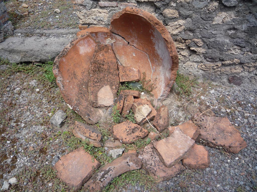 VII.1.36 Pompeii. October 2009. 
Looking north towards doorway leading to south-west end of atrium, and broken terracotta pot. Photo courtesy of Jared Benton.