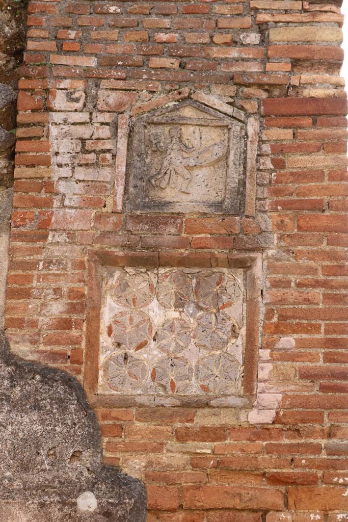 VII.1.36 Pompeii. December 2018. 
Ithyphallic and geometric plaques outside VII.1.36 Modestus Bakery, on pilaster on east side of entrance doorway.
Photo courtesy of Aude Durand.