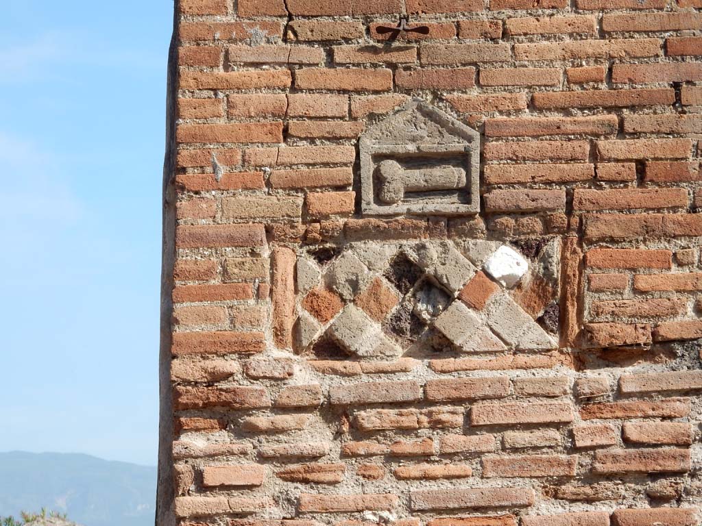 VII.1.36 Pompeii. June 2019.  
Phallus and rhomboid plaques outside VII.1.36 Modestus Bakery, on pilaster on west side of entrance doorway.
Photo courtesy of Buzz Ferebee.