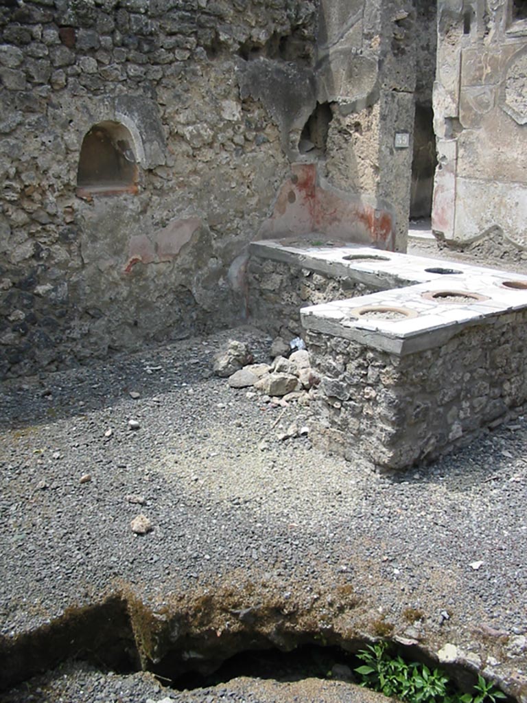 VII.1.39 Pompeii. May 2003. 
Looking north-west across counter, with niche in west wall. Photo courtesy of Nicolas Monteix.