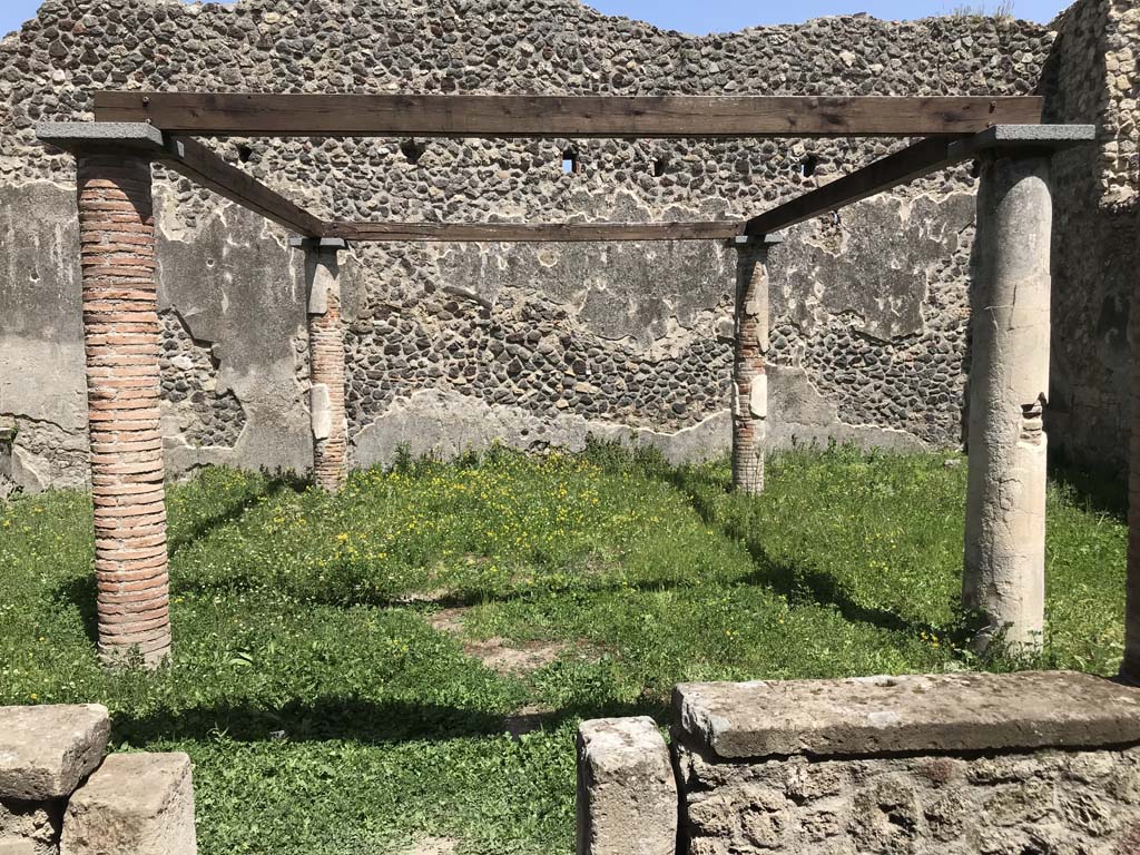 VII.1.47 Pompeii. April 2019. Looking east across site of shaded triclinium in peristyle 19. Photo courtesy of Rick Bauer.
According to Jashemski – 
“The four small columns in the garden probably supported a pergola which shaded a wooden triclinium.
An elegant triclinium (b) (now room 8) to the left of the passageway leading to the peristyle had a wide window opening into the west portico, giving a good view into the garden. The window could be closed with four vertical folding leaves”.
See Jashemski, W. F., 1993. The Gardens of Pompeii, Volume II: Appendices. New York: Caratzas. (p.171).