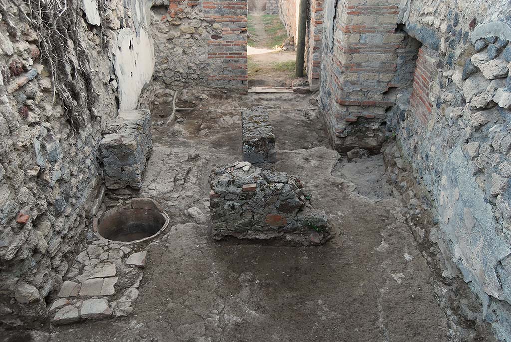 Fig. 11 – Pompéi, boulangerie VII 2, 3.6-7 – Nettoyage dans la salle de façonnage, vue du Nord.
Au-delà des pieds de table, seul un remblai (inachevé ?) a été mis en évidence.
Pris du nord.
Cliché : R. Cuvilier /EFR.