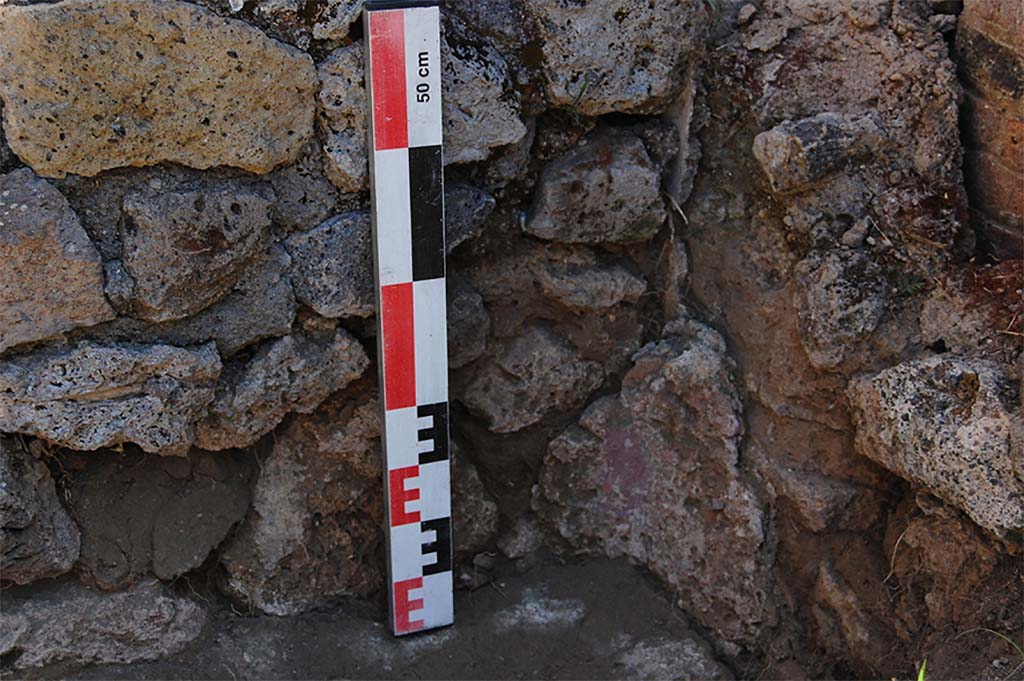Fig. 26 – Pompéi, boulangerie VII 2, 3.6 – Angle sud-oriental du péristyle, au point de contact entre le bassin et le bras méridional.
Vue du nord-ouest.
La succession des enduits et mortier permet de suivre les trois phases : construction du péristyle, aménagement du bassin, réfection de la rigole.
Cliché : N. Monteix – EFR.