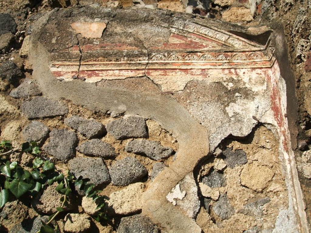 VII.2.6 Pompeii. December 2004. Stucco decoration in cubiculum with vaulted ceiling in north-east corner of atrium.  This cubiculum had a red zoccolo subdivided into panels, in the central panel was a plant with long leaves.
In the middle area of the wall, it was painted white, showing two panels divided by a narrow compartment with a candelabra painted between them. The upper area of the wall was also white, subdivided into squares edged in red. The stucco edged vault of the room was above this.