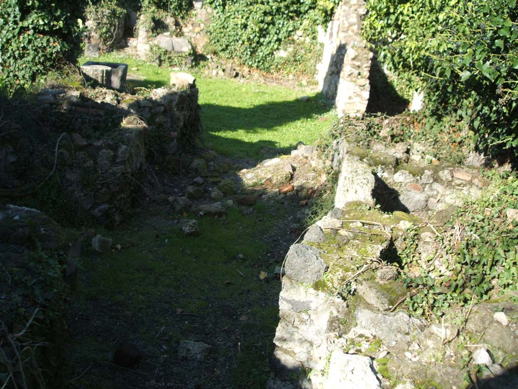 VII.2.11 Pompeii. December 2004. Looking north across remains of masonry in south-east corner of peristyle.  
Nine lead kettles set in masonry with a place for a fire underneath were found here.  
See Mau, A., 1907, translated by Kelsey F. W. Pompeii: Its Life and Art. New York: Macmillan. (p.385-6).
