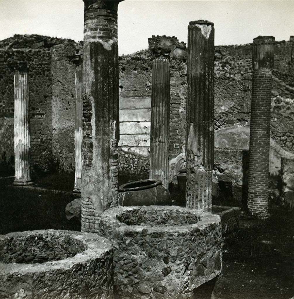 VII.2.11 Pompeii. 1912. Looking north-west across masonry towards north wall of peristyle.
At the time of excavation, in a recess of the north wall, several wooden shelves were fixed into the wall on which were found glass containers with the colours necessary for the activities of the dyers. 
Photo by Esther Boise Van Deman (c) American Academy in Rome. VD_Archive_Ph_238.