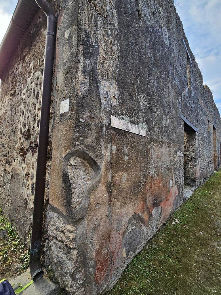 VII.2.16 Pompeii. November 2024. 
Inner west side of entrance doorway and exterior street wall on west (right) side of entrance doorway between VII.2.16 and VII.2.17.
Photo courtesy of Annette Haug.