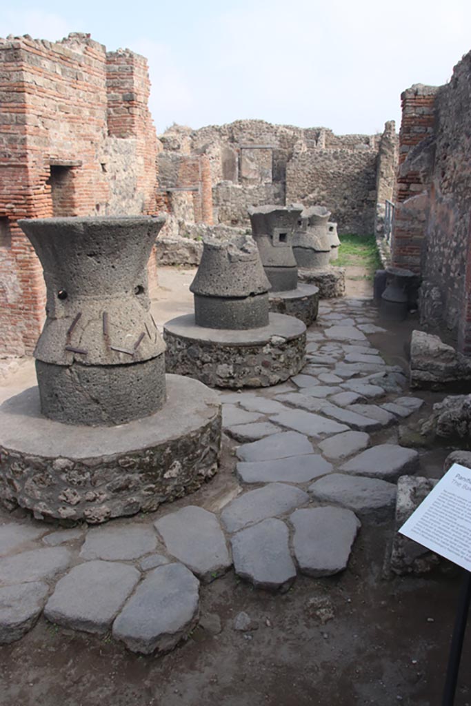 VII.2.22 Pompeii. October 2023. 
Looking east towards mills in bakery from entrance doorway. Photo courtesy of Klaus Heese.