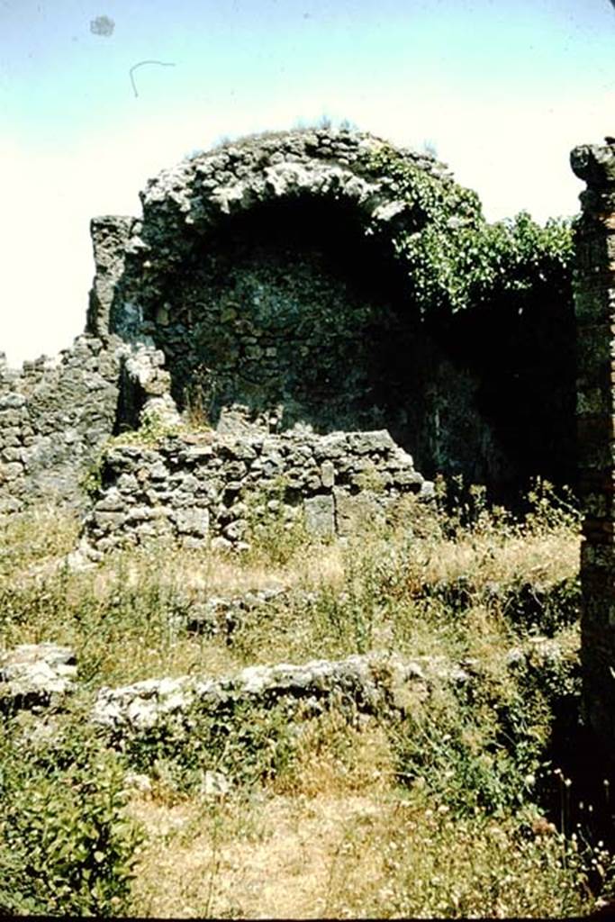 VII.2.23 Pompeii. 1957. Looking east to rear of house across small garden to small vaulted room at rear.  Photo by Stanley A. Jashemski.
Source: The Wilhelmina and Stanley A. Jashemski archive in the University of Maryland Library, Special Collections (See collection page) and made available under the Creative Commons Attribution-Non Commercial License v.4. See Licence and use details. J57f0354     
According to Wilhelmina “at the rear of this house (excavated 1844-67) was a small garden enclosed by a passageway on the north, west and south”.
See Jashemski, W. F., 1993. The Gardens of Pompeii, Volume II: Appendices. New York: Caratzas. (p.174)