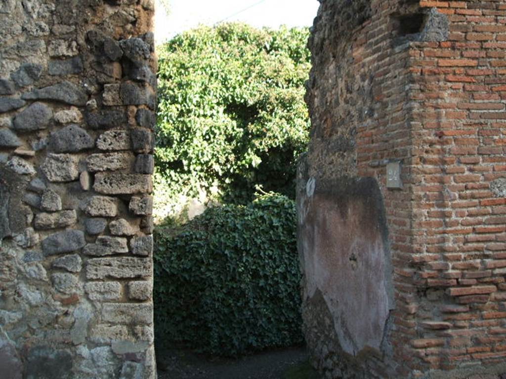 VII.2.24 Pompeii. December 2004. Entrance doorway looking towards south wall.
The wall would have been painted with a black zoccolo (lower part) and a white wall above.