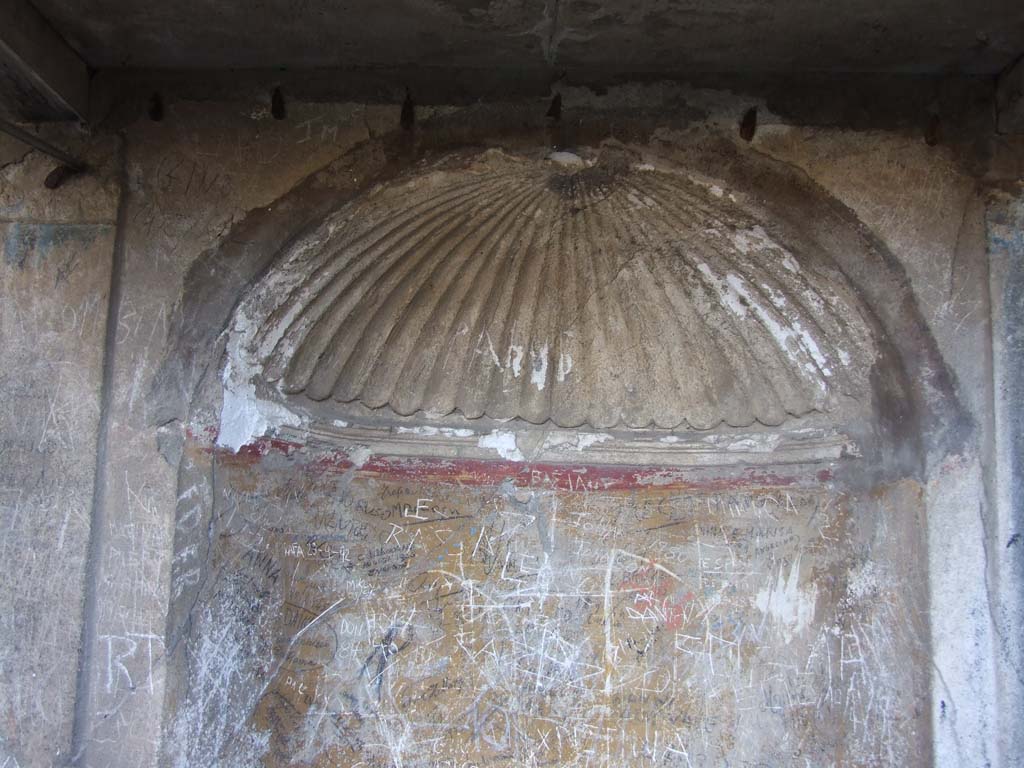 VII.3.6 Pompeii. December 2006. Semi-circular niche in the rear wall with vaulted ceiling adorned with a stucco shell.
The walls of the niche were painted orange.