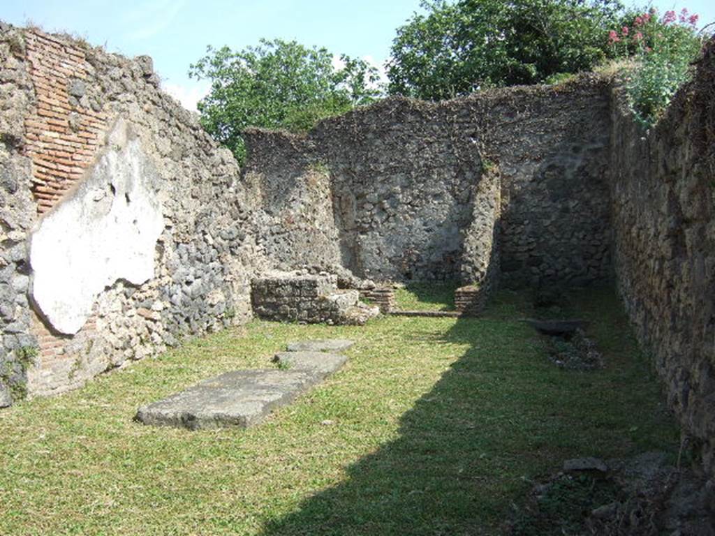 VII.3.10 Pompeii. May 2006. Looking south across shop towards steps to upper floor in front of rear room, on left. Four lava paving slabs are laying on the ground to the left.