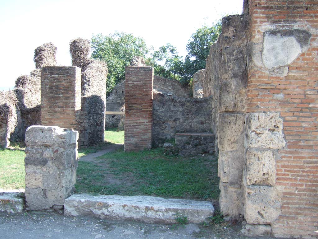 VII.3.11 Pompeii. September 2005. Looking south at entrance with steps to upper floor.
According to Helbig, on the outside wall between Strada della Fortuna 26 and 25, (VII.3.11 and VII.3.10), 
on the right, there was a faint trace of a painted Lar with a situla (a bronze vessel).
See Helbig, W., 1868. Wandgemälde der vom Vesuv verschütteten Städte Campaniens. Leipzig: Breitkopf und Härtel. (no: 93) 
According to Frohlich, the painting of a Lar with situla was found on the façade, exact position unknown. Now destroyed.
See Fröhlich, T., 1991. Lararien und Fassadenbilder in den Vesuvstädten. Mainz: von Zabern. (p. 325, F47)