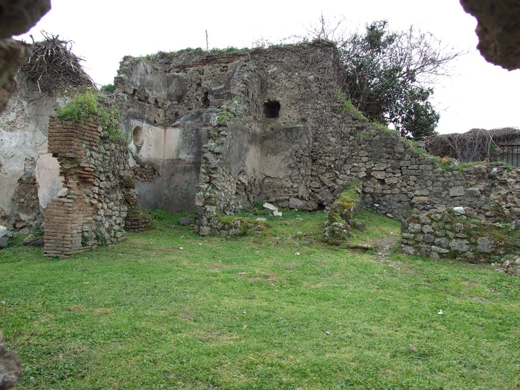 VII.3.13 Pompeii. March 2009. Looking south-west across garden area. 
South side. Large triclinium and passage to kitchen & latrine.
West side of garden area. Doorways to two cubicula & passage room, leading to VII.3.11