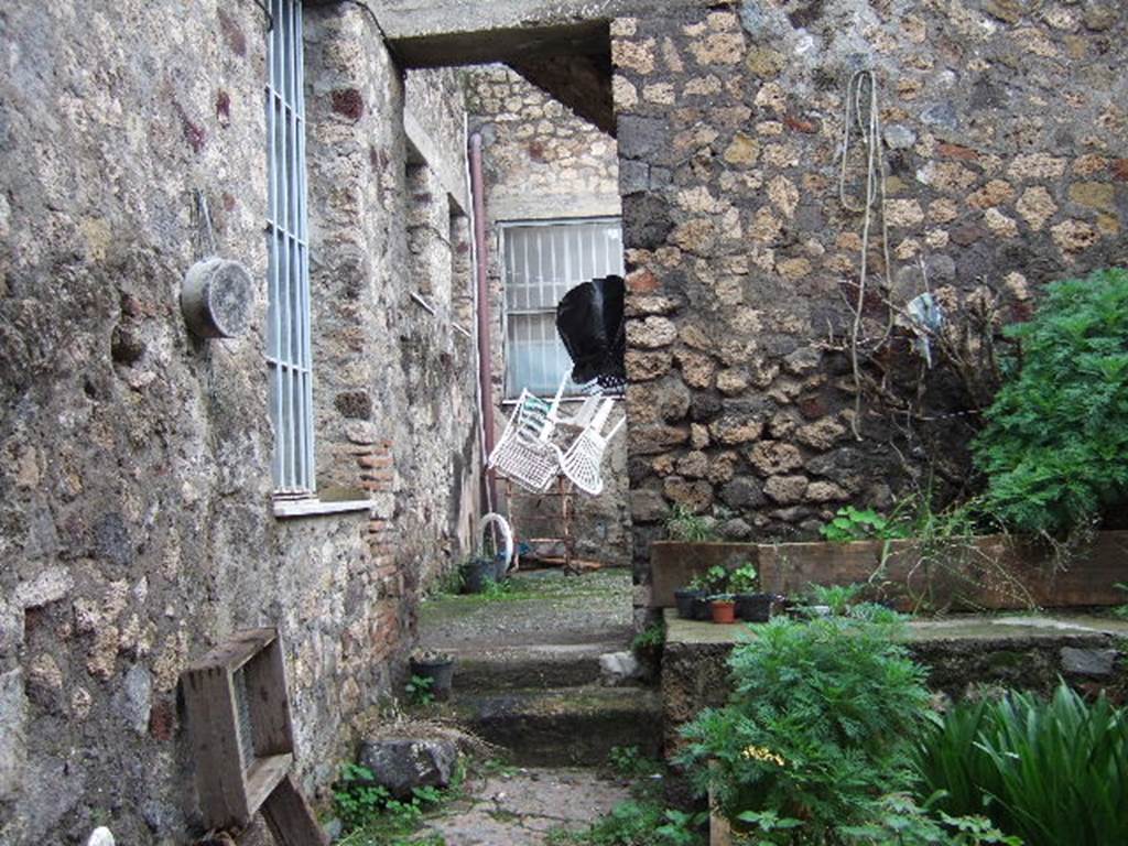 VII.3.24 Pompeii. Looking north from entrance.  According to Fiorelli, this was a workshop that was part of the house next-door.  This area had two furnaces, one basin and a hearth all mostly destroyed. The latrine was next to the entrance, together with a small room. Then, through the doorway with the two steps (possibly modern), was the atrium.
On the south side of the atrium were stairs to the upper floor, and on the north side was a cubiculum.
See Pappalardo, U., 2001. La Descrizione di Pompei per Giuseppe Fiorelli (1875). Napoli: Massa Editore. (p.87)
