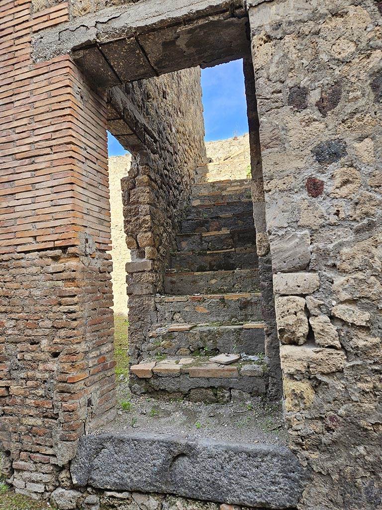 VII.3.27 Pompeii. November 2024. 
Steps to upper floor, with doorway into VII.3.28 in west wall. Photo courtesy of Annette Haug.