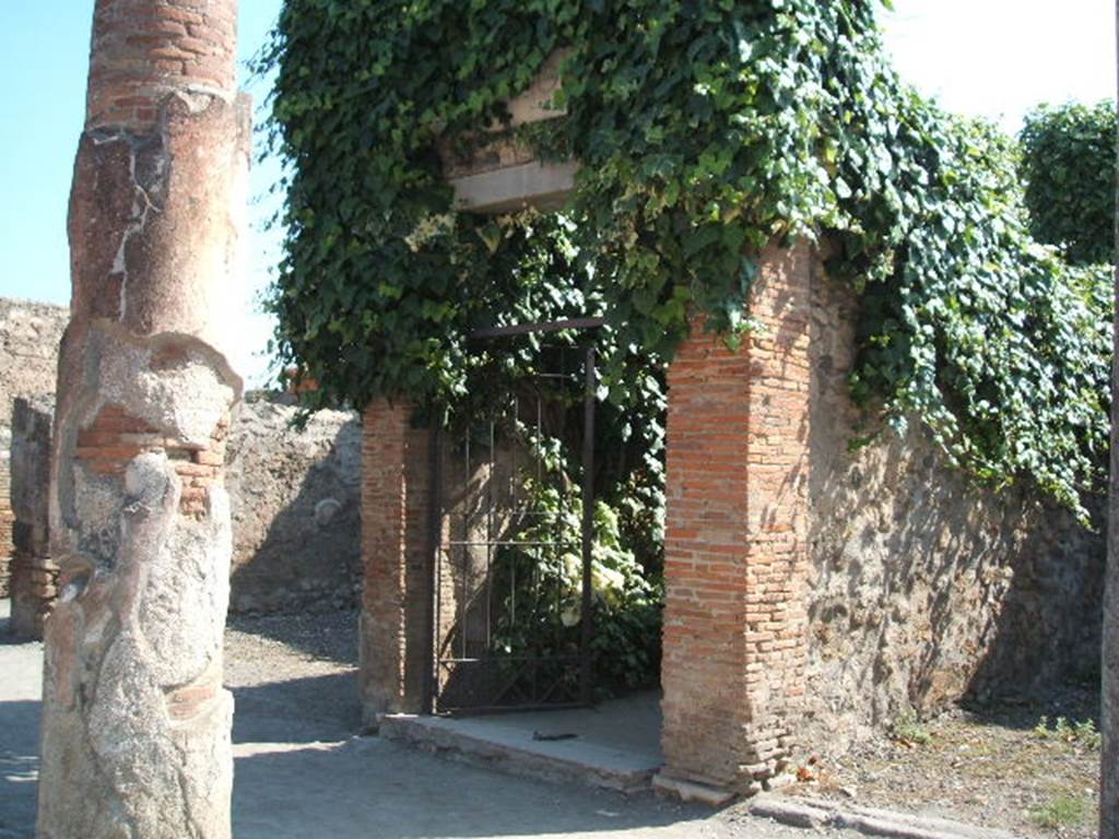VII.4.10 Pompeii. September 2005. Entrance
According to Gell –
“Nearly opposite the entrance to the Baths, which occupies the centre of this street on the left-hand side, is a house on the right hand-side of more consequence than the rest. It has received the name of the House of Bacchus, from a large painting of the god yet existing on a wall opposite the entry.
Canals for the introduction of water are found in the Atrium, which has been surrounded by a small trough, or parterre of natural flowers, the side of which next the eye is painted blue, to represent water on which boats are floating. The wall behind this is painted with pillars, between which run balustrades of various forms, and upon these perch cranes and other birds, not badly painted, with a background of reeds or plants, and a sky visible behind. The effect must have been pretty when the whole was perfect.  In the same house is the picture of a male and female sitting at the base of a pillar, attended by three cupids. In the background is a tree, with mountains in the distance. Nothing can exceed the grace of these figures in the original, and on that account, an outline of the picture has been, among others, selected for this work. See Plate XII (and see below).
In the same house is a pavement of coloured marbles, in the nature of opus Alexandrinum, which is pretty and is therefore given at the end of this work in Plate LXXXVIII.”
See Gell, W, 1832.  Pompeiana: Vol 1.  London: Jennings and Chaplin, (p.39-40)