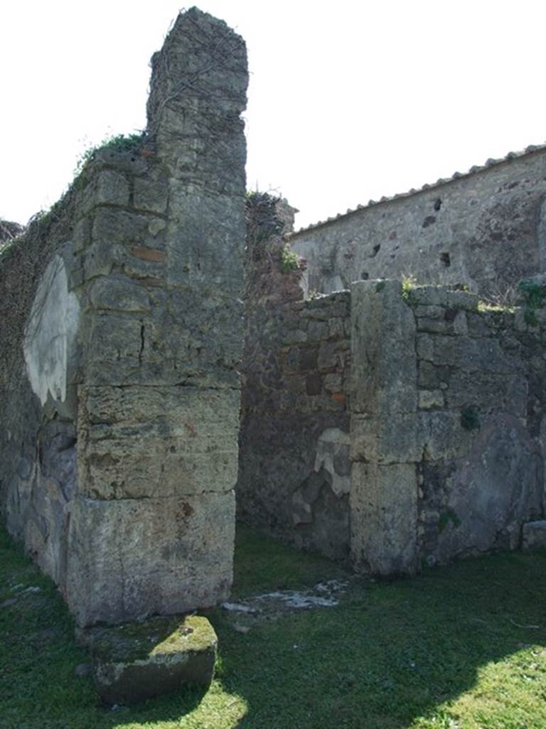 VII.4.57 Pompeii. March 2009. Pillar between the tablinum (left) and doorway to room 8, corridor to rear (right).  
The large block of lava stone in front of the pillar is the remains of the base for the arca/strong-box, which was originally surrounded by a small rectangular wall.
(PPM and Avellino – room q, corridor, area f, strong-box or arca.)