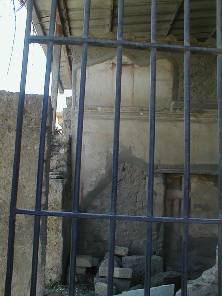 VII.4.62 from VII.4.63, Pompeii. May 2005. 
Looking south into cubiculum towards the remains of the upper south wall, across a site of a staircase to upper floor, through window in shop at VII.4.63.
