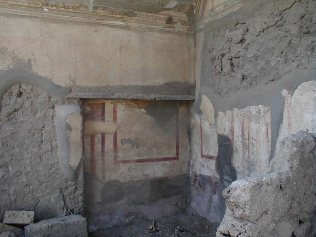 VII.4.62 from VII.4.63 Pompeii. 
South-west corner of cubiculum, with recess for bed set into south wall, in centre. The west wall is on the right.