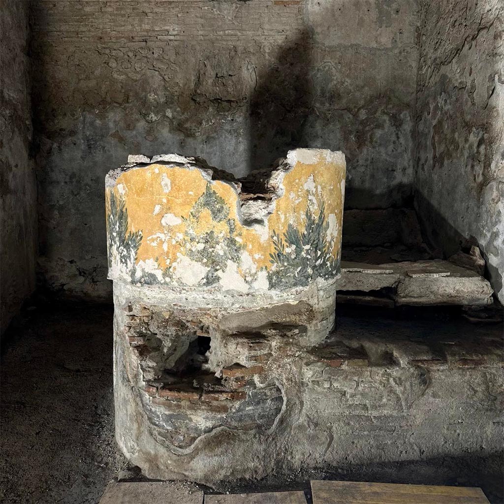 VII.5.8 Pompeii. March 2024. Caldarium 50, and labrum 52.
The masonry support of the labrum, with vegetal decoration, in the calidarium after restoration.
The calidarium was equipped with a small tub for immersion baths and the labrum of which only the masonry support of the tub remains. 
The tepidarium and calidarium were both equipped with a floor with a cavity supported by small pillars (suspensurae) for the passage of hot air, which then also flowed into the walls equipped with hollow tegula mammata tiles. The floor of the calidarium was destroyed in the earthquake of 62 AD. and at the time of the eruption it was being renovated, as also demonstrated by a pile of mosaic tiles found in a corner of the room at the time of the excavation and still preserved on site.
See PAP E-Journal 02 – 8.3.2024, p. 5-6 fig. 9. 
Photograph © Parco Archeologico di Pompei.