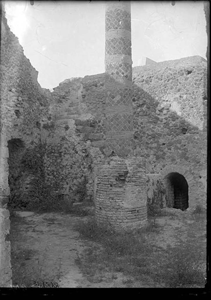 VII.5.10 Pompeii. 1931. Courtyard (33) with column (34), staircase (35) to caldarium, and entrance (36) to praefurnium (boiler) area.
DAIR 31.2528. Photo © Deutsches Archäologisches Institut, Abteilung Rom, Arkiv. 
The courtyard is accessible off Vicolo delle Terme.
On the left is the entrance corridor (32) to the praefurnium.
The ramped masonry staircase (35) allows access to the roof of the caldarium.
The circular brick base had a column (34) erected on it after the earthquake, probably to support a sundial.
The smaller arch on the right is entrance (36) to praefurnium (boiler) area.
See Carratelli, G. P. ed., 1990-2003. Pompei: Pitture e Mosaici. Vol. VII. Roma: Istituto della enciclopedia italiana, p. 172. 
Alternative sources, such as Niccolini, have suggested the column is a roof support.