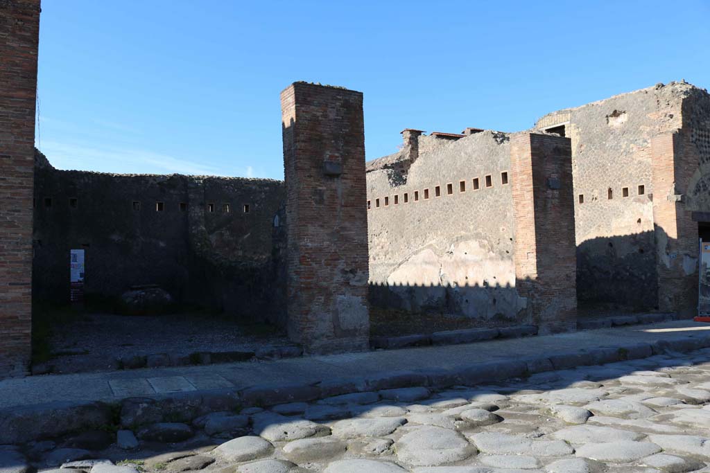 VII.5.21, Pompeii, on left. December 2018. 
Looking west to shop entrances on west side of Via del Foro, VII.5.21/22/23. Photo courtesy of Aude Durand.