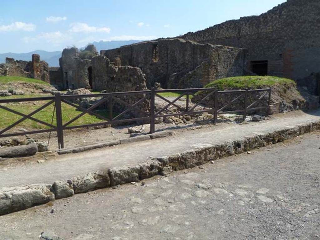 VII.6.5/4/3 Pompeii. May 2011. Looking south-west towards sites of doorways on Via delle Terme. On the left is the thicker base-stone of the steps to the upper floor at VII.6.5.
In the centre is a wider doorway to the shop at VII.6.4. The room on the right of the stone dividing wall would have been part of VII.6.3. On the right the bar at VII.6.2/1 can be seen.
Photo courtesy of Michael Binns.