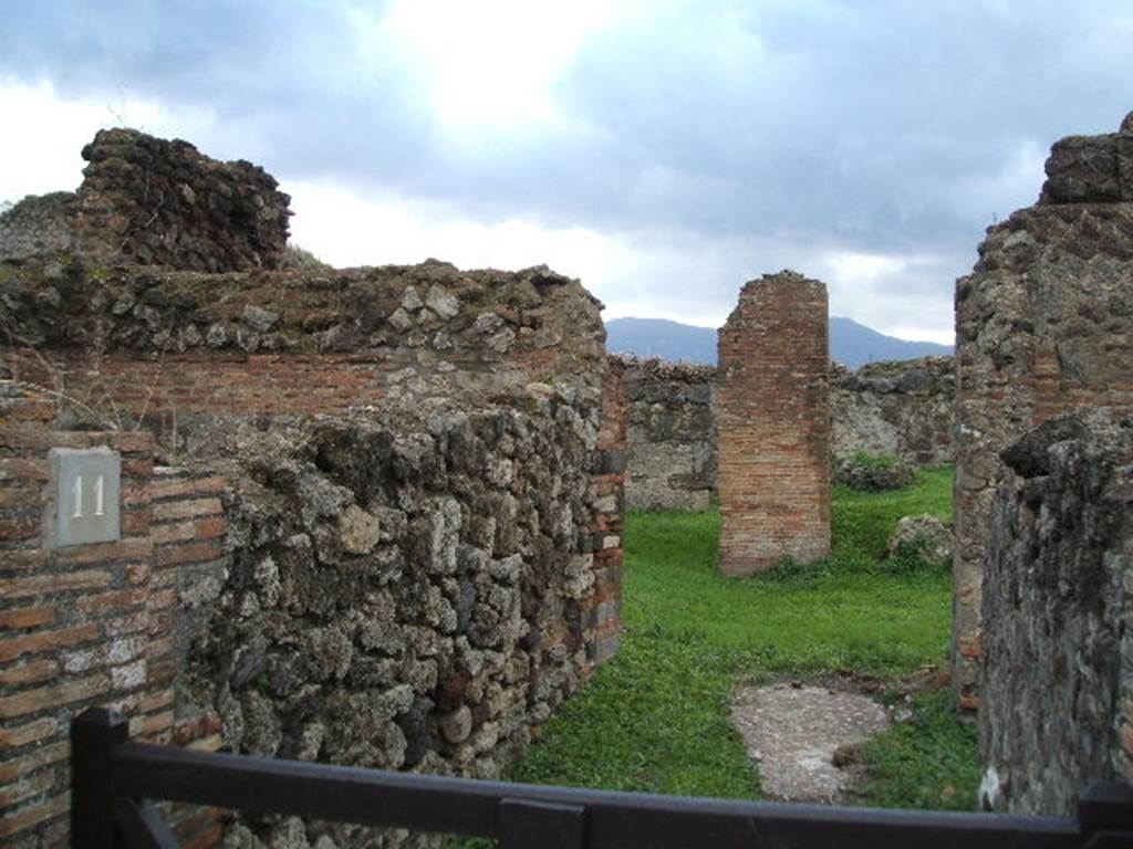 VII.6.11 Pompeii. December 2004. Looking south along entrance corridor towards site of atrium. This area was affected by the bombing in September 1943.  A photograph of the area can be seen showing the same brick pilaster, about the only thing left standing in the area. See Garcia y Garcia, L., 2006. Danni di guerra a Pompei. Rome: L’Erma di Bretschneider. (p.104, Fig 233 (Foto SAP neg. no.176)