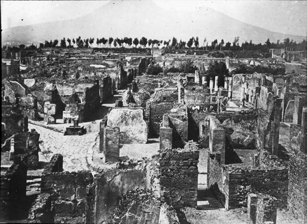 VII.6.11 Pompeii. Looking north across north side of insula VII.6, lower photo, across to Via Consolare and junction with Vicolo di Modesto, centre left, and VI.6, centre right. The entrance corridor of VII.6.11 can be seen on the right of the photo, leading into the atrium. Photo by permission of the Institute of Archaeology, University of Oxford. File name instarchbx208im011. Source ID. 44337.