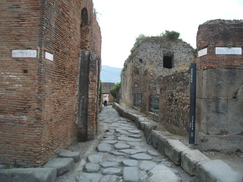 VII.5 Pompeii. May 2005. Vicolo delle Terme looking south. The reservoirs at VII.6.17 are the tall buildings on the right. The water tower at the Forum Baths is on the left.
According to Clarke – 
“The Piscina or reservoir is separated form the baths themselves by the street, which opens onto the Forum. The pipes which communicated between the reservoir and the bath passed over an arch thrown across the street. This arch was perfect when the excavation was made; now only the shoulders remain, in which the pipes above-mentioned are still visible.” 
See Clarke, W. (1833). Clarke’s Pompeii. Boston, USA, Lilly, Wait, Colman and Holden, (p. 158).