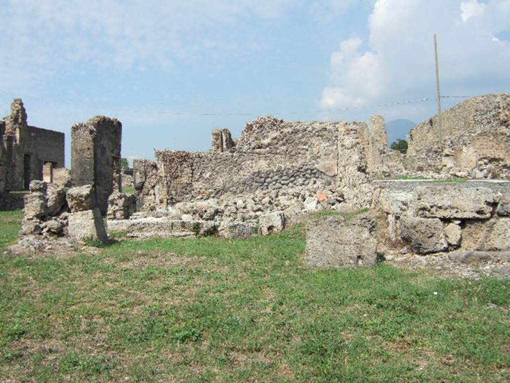 VII.6.27 in lower right-side corner, with VII.6.28 on left and in background. September 2005. According to Fiorelli and Eschebach, this shop had a staircase to the upper floor against the west wall, a doorway linking to VII.6.26 in the east wall, and a rear room. See Pappalardo, U., 2001. La Descrizione di Pompei per Giuseppe Fiorelli (1875). Napoli: Massa Editore. (p.160)  See Eschebach, L., 1993. Gebäudeverzeichnis und Stadtplan der antiken Stadt Pompeji. Köln: Böhlau. (p.296)