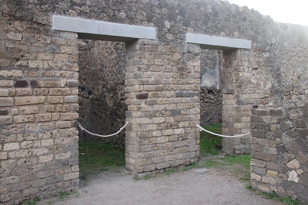 VII.7.2 Pompeii. October 2024. 
South side of atrium, with doorway to room “d” on left, and room “i”, visible behind the wall, on right, in room “h”.  Photo courtesy of Klaus Heese.