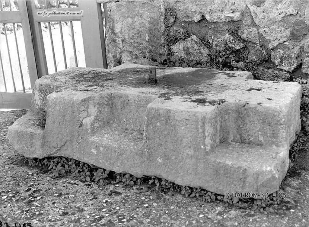 VII.7.5 Pompeii. 1932. Base for strong-box/money chest, found on west side of entrance doorway in atrium.
According to Pernice –
Chest base. Found in the atrium, to the left of the entrance. 
At the four corners of this travertine base there are notches for square post feet. 
At the front there is another shallow notch, so that the chest must have stood on 3 feet at the front. 
At the front edge of the surface there is an iron spike for fastening the chest.
See Pernice, E., 1932. Hellenistische Tische, Zisternenmündungen, Beckenuntersätze, Altäre u. Truhen. Berlin, p. 73, Taf. 44.1.
DAIR 32.1105. Photo © Deutsches Archäologisches Institut, Abteilung Rom, Arkiv. 
Thanks to Espen B. Andersson for assisting us in our interest in money-chests.