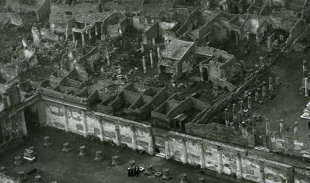 VII.7.5 Pompeii. 1944, detail taken from USAAF aerial photo. Looking north-west across the Basilica and Via Marina, lower left in photo.
On the north side of the Via Marina, in the upper part of the photo, the house of House of Romulus and Remus (VII.7.10), and House of Tryptolemus (VII.7.5 and VII.7.2) can be seen on the west side of the Temple of Apollo, which is on the right. 
Photo courtesy of Rick Bauer.