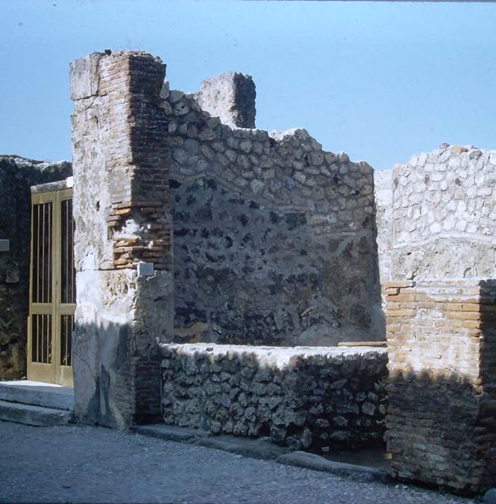 VII.7.9, Pompeii. November 1961. Entrance doorway with bar podium/counter.
On the left is the entrance doorway of VII.7.10, The House of Romulus and Remus.
Photo courtesy of Rick Bauer.