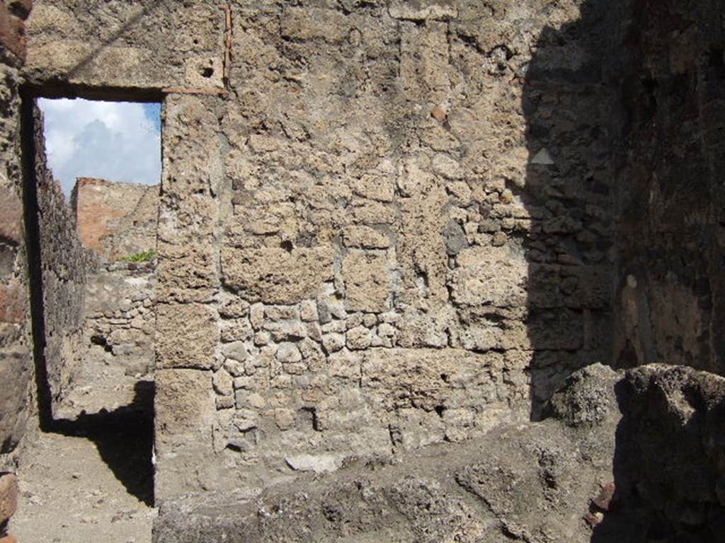 VII.7.11 Pompeii. September 2004.  North wall with doorway to rear room, (behind entrance at VII.7.12 ), with corridor to rear.