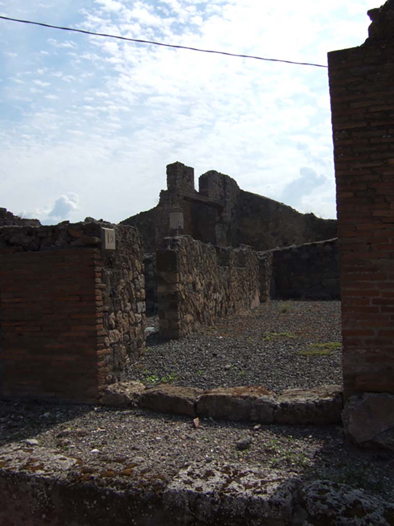 VII.7.19 Pompeii. September 2005. Looking south to entrance doorway.
According to Garcia y Garcia, due to the bombardment in 1943, a part of the atrium and two nearby rooms were destroyed.
The destruction caused the loss of plaster and fourth style decoration.
See Garcia y Garcia, L., 2006. Danni di guerra a Pompei. Rome: L’Erma di Bretschneider. (p.116).