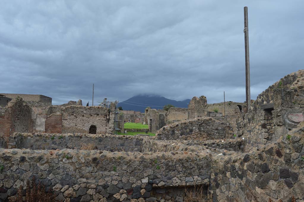 VII.7.23 Pompeii. March 2018. 
Looking north from upper walls of room on north side of atrium, towards VII.6.29, with arched doorway, and atrium/tablinum of VII.6.28, in green grass.  
Foto Taylor Lauritsen, ERC Grant 681269 DÉCOR.