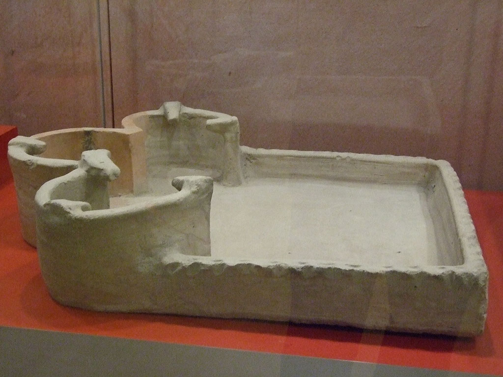 VII.7.29 Pompeii. Terracotta portable stove in storage. From Pompeii possibly from on top of the fixed stove of a bar.
Pots may have stood on the three "hotplates" as well as items in the base.
PAP inventory number 56305.
Photographed at “A Day in Pompeii” exhibition at Melbourne Museum. September 2009.