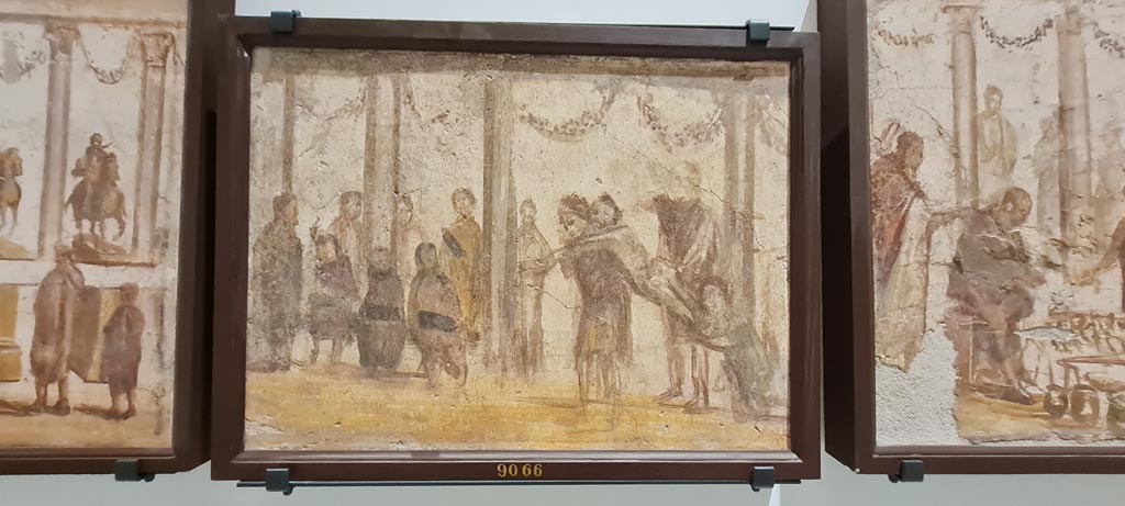 II.4.3 Pompeii. April 2023. Paintings of the Forum frieze, on display in “Campania Romana” gallery in Naples Archaeological Museum.
In centre (inv. 9066) – Lezione di lettura e punizione di scolaro. (Reading lesson and punishment of a pupil.)
Photo courtesy of Giuseppe Ciaramella.