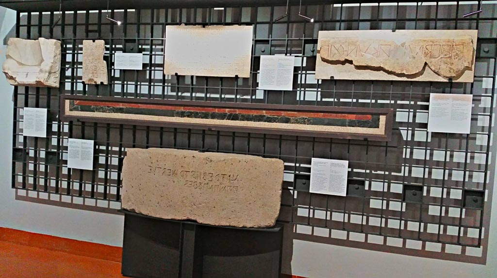 VII.7.32 Pompeii. 
Centre of photo, part of red and green/black floor mosaic with epigraph, on display in Naples Archaeological Museum, inv. 113398.
Ovius Campanius … quaestor, by decree of the assembly, with the money of Apollo… had (this) made.
The inscription, in Oscan written from right to left, refers to the restoring of the floor of the Temple of Apollo with the money of the offerings of the faithful.
Photo courtesy of Giuseppe Ciaramella, June 2017.