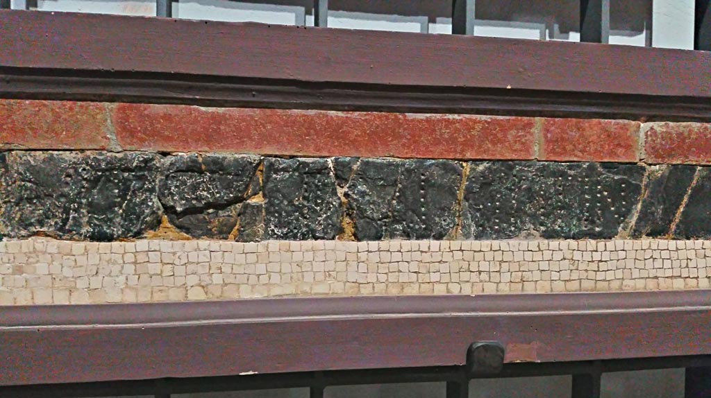 VII.7.32 Pompeii. 
Detail of red and green/black floor mosaic with (part of the) epigraph, on display in Naples Archaeological Museum, inv. 113398.
Photo courtesy of Giuseppe Ciaramella, June 2017.