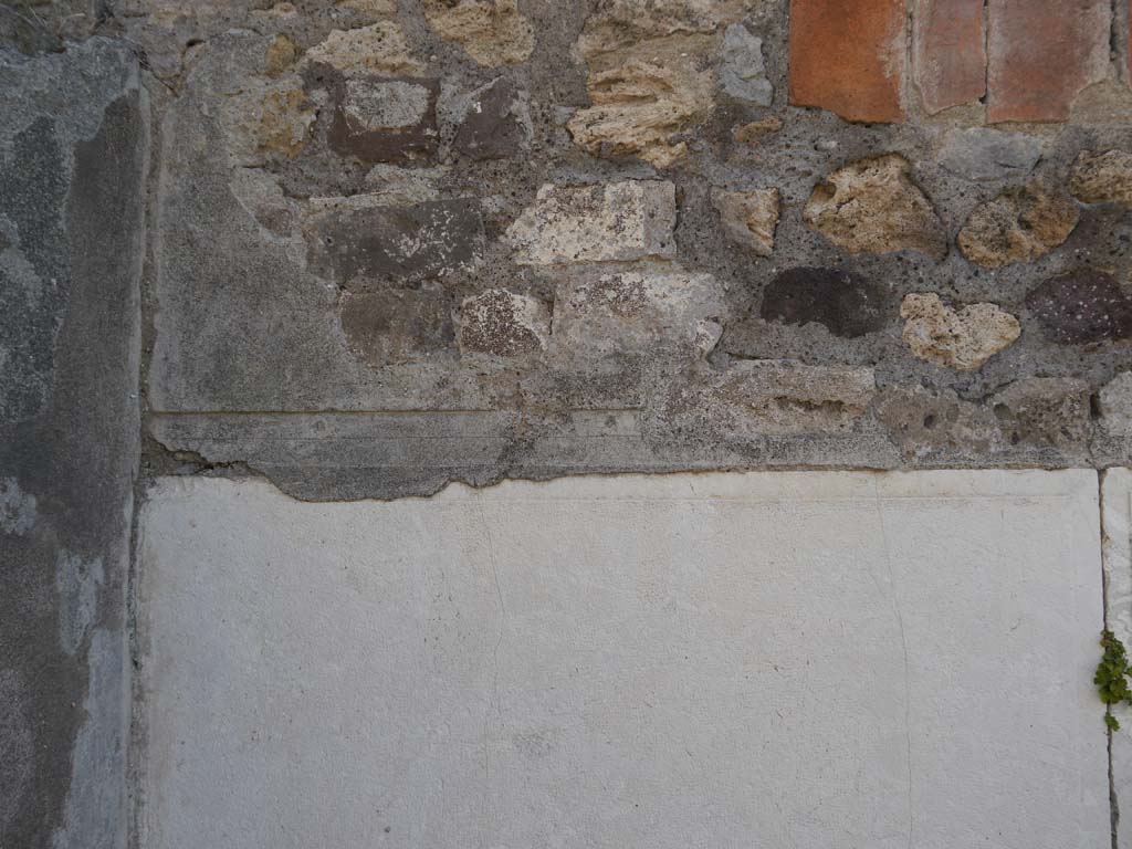VII.7.32, Pompeii. September 2018. Detail of south-west corner of cella base, below steps. Looking east.  
Foto Anne Kleineberg, ERC Grant 681269 DÉCOR.