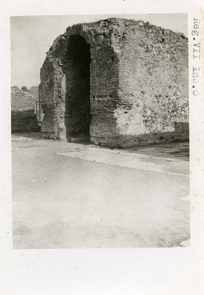 VII.8 Pompeii Forum. Pre-1937-39. Arched monument of Augustus (?) in centre of south side.
Photo courtesy of American Academy in Rome, Photographic Archive. Warsher collection no. 1123.
According to Van Buren –
“The centre of the south end of the Forum is occupied by a large rectangular arched structure of masonry, faced with opus incertum and tiles. It lies in the axis of the Capitolium and of the Forum. Mau (Note 2; Rom. Mitth, XI, 1896, pp.153 f.) proposed the conjecture that this is a base which once supported a statue of Augustus, and he made use of this conjecture in connection with an elaborate theory as to the identification of the various statues which once stood on the bases in the Forum. He assumes a colossal bronze standing statue as best meeting the conditions of proportion and stability.
In the first place must be advanced an objection on the score of historical improbability. A glance at our Pl.25, fig.4 will show that if there ever was a standing statue on the arched structure in question, the statue was a colossus so huge as absolutely to dominate the Forum, and more than challenge comparison with the cult statue of Jupiter in the Capitoline temple facing. It is inconceivable that Augustus would have permitted, or that Tiberius would have tolerated, the erection of such a statue in Italy during their reigns: it was reserved for Nero and Domitian to assimilate themselves to divinity in so outspoken a fashion. ………………………………
I have no hesitation in proposing to identify the arched structure as simply the Ianus of Pompeii, and to associate its erection in its present form with some renewal or extension of the privileges of the city under the early Empire.” 
See Van Buren, Albert William. The Arch at the South End of the Forum. Part III in Memoirs of American Academy in Rome, 1918, (p.72-73).