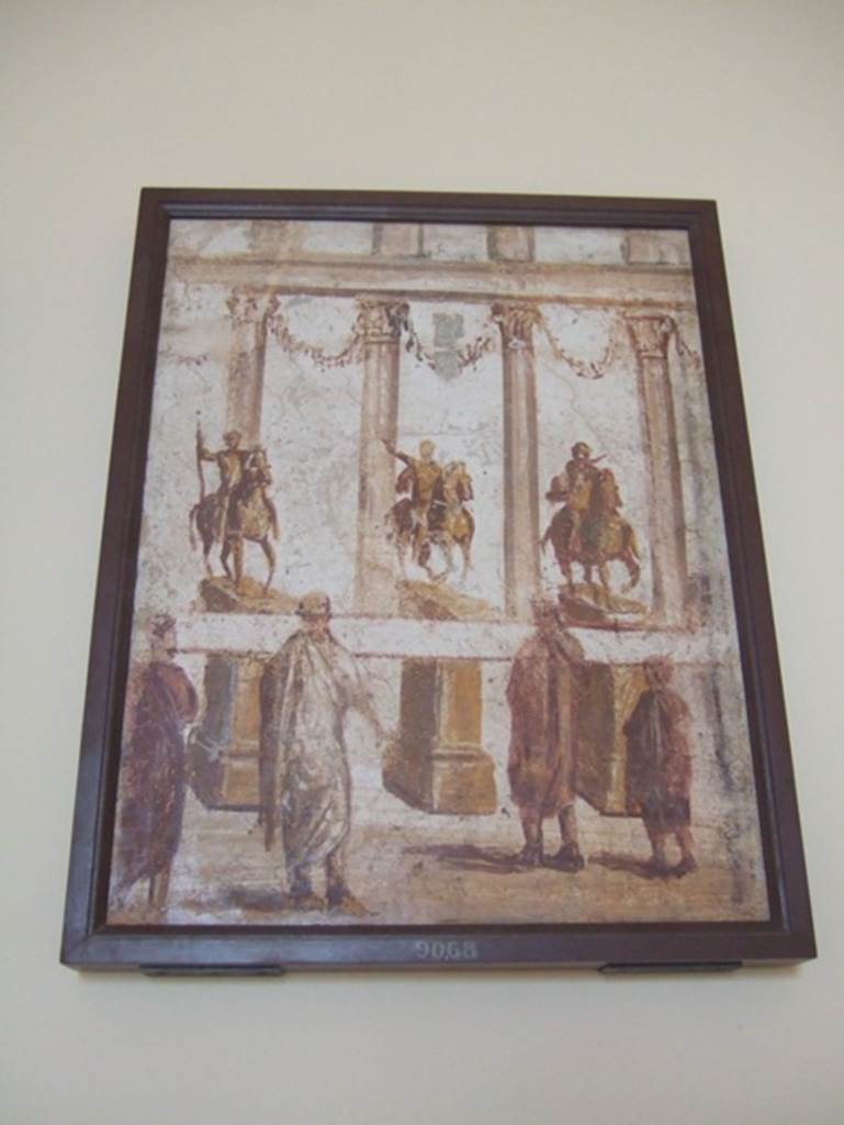 Part of the “Forum Frieze” found in the atrium of II.4.3.  
Forum scene of people reading a banner across the front of the equestrian statues.  Now in Naples Archaeological Museum.  Inventory number 9068.