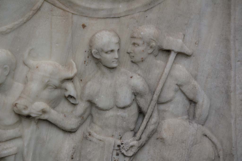 VII.9.2 Pompeii. April 2014. Detail from west side of Altar.  Photo courtesy of Klaus Heese.
According to Mau, these figures are the victimarius or slayer and an assistant who are bringing a bull to the altar for sacrifice.